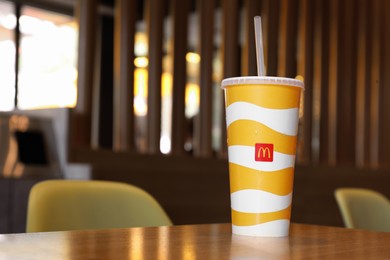 Photo of MYKOLAIV, UKRAINE - AUGUST 11, 2021: Cold McDonald's drink on table in cafe. Space for text