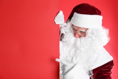 Photo of Santa Claus holding empty banner on red background