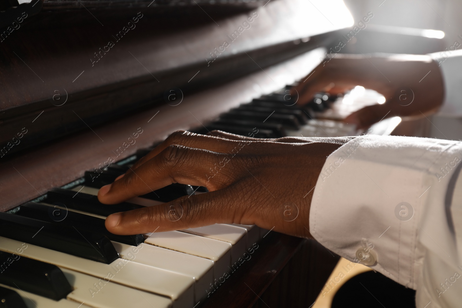 Photo of African-American man playing piano, closeup. Talented musician