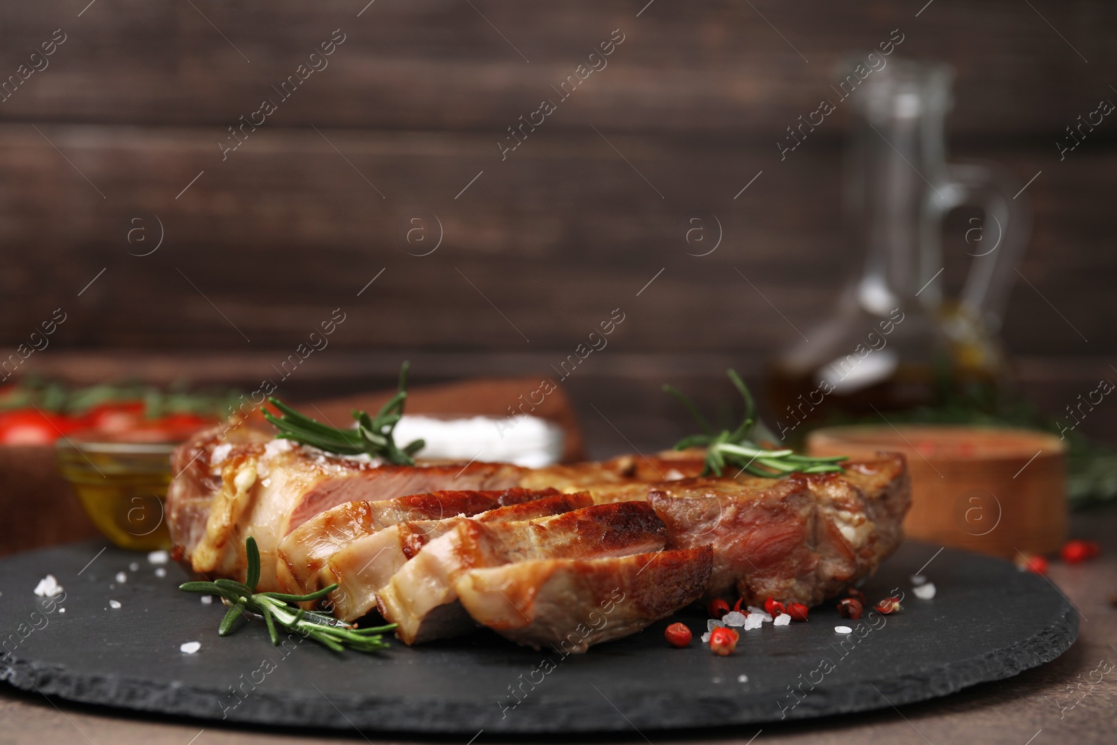 Photo of Pieces of delicious fried meat with rosemary and spices on table, closeup