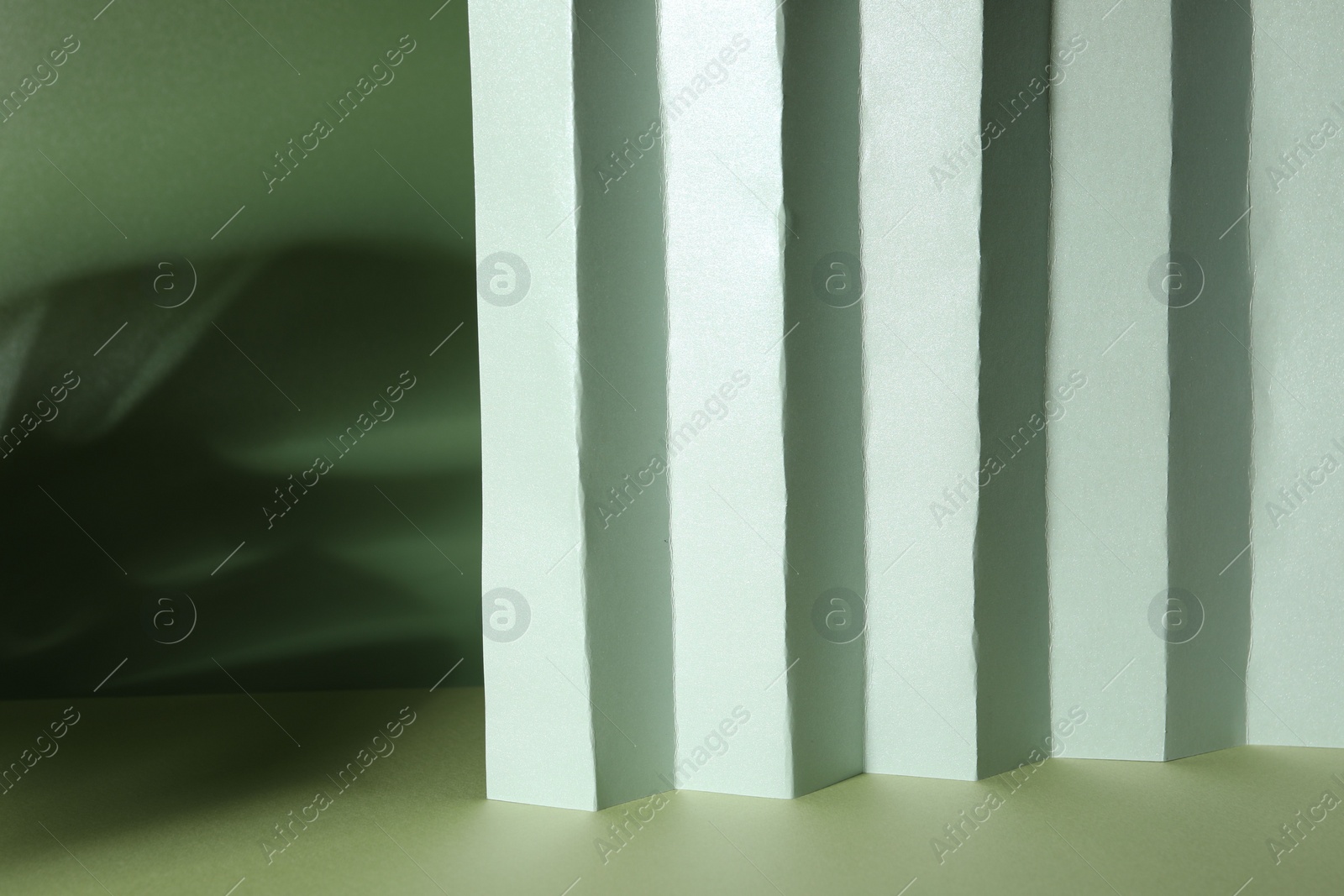Photo of Presentation of product. Paper and shadows on light green background. Space for text