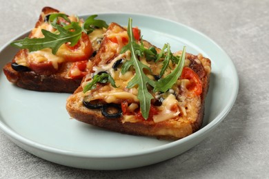 Photo of Tasty pizza toasts served on grey table, closeup