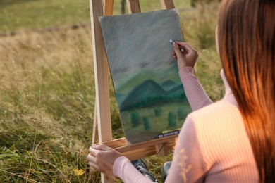 Photo of Woman drawing landscape with soft pastels outdoors, closeup