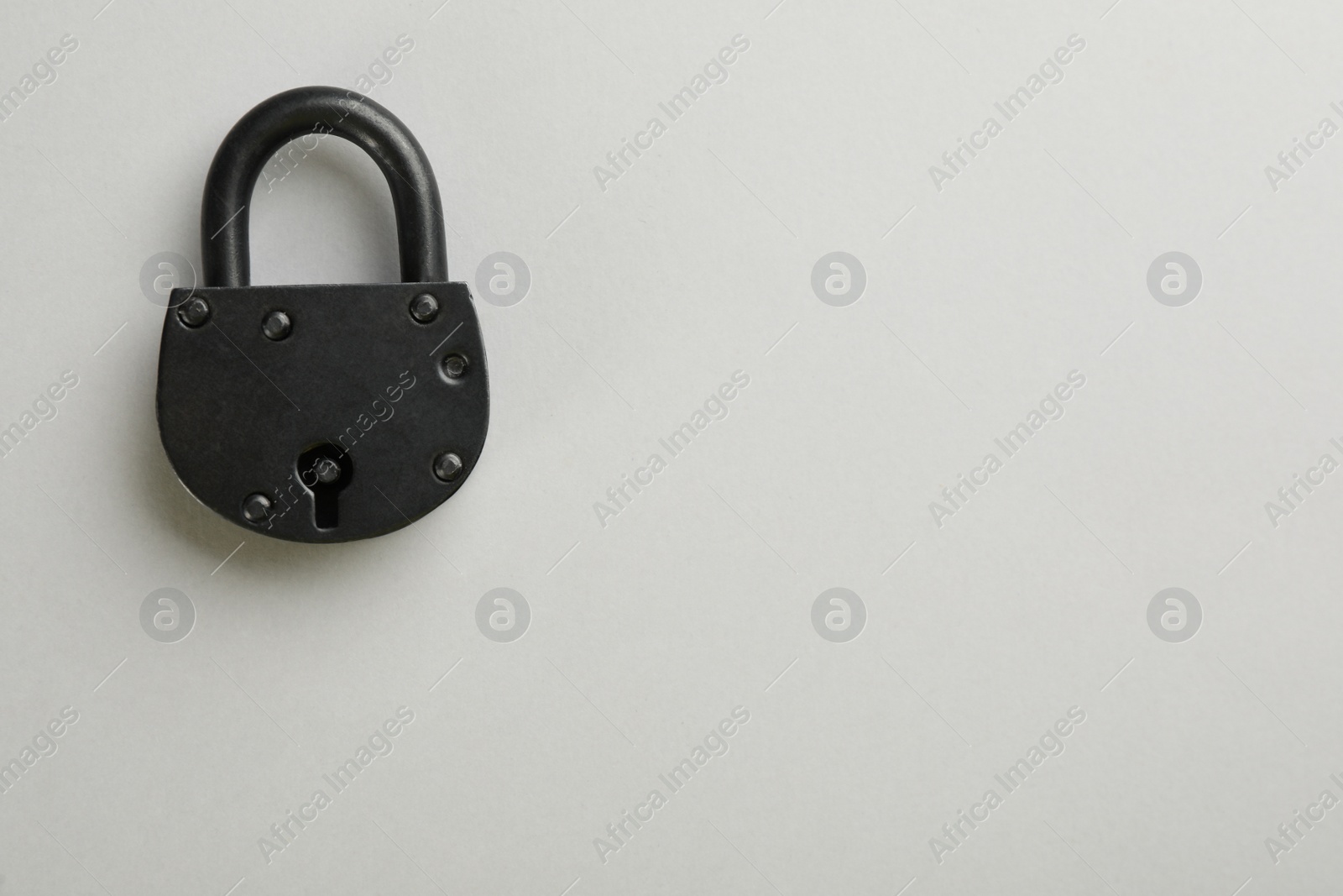 Photo of Vintage padlock on light background, top view. Space for text