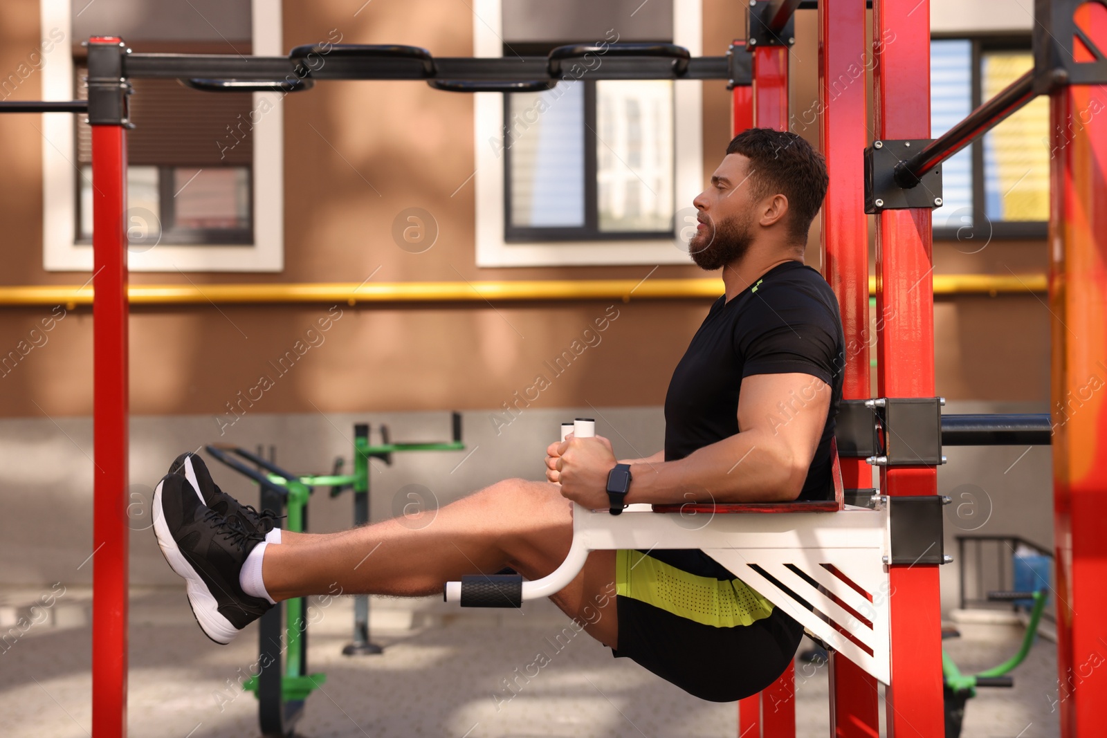 Photo of Man doing leg rise exercise at outdoor gym