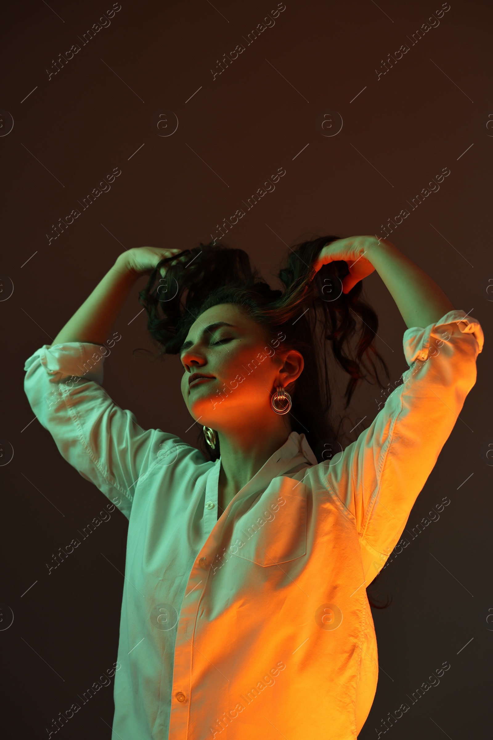 Photo of Portrait of beautiful young woman on color background with neon lights