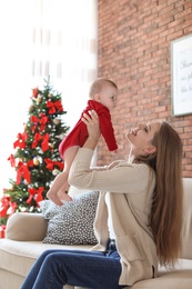 Photo of Young woman with baby celebrating Christmas at home