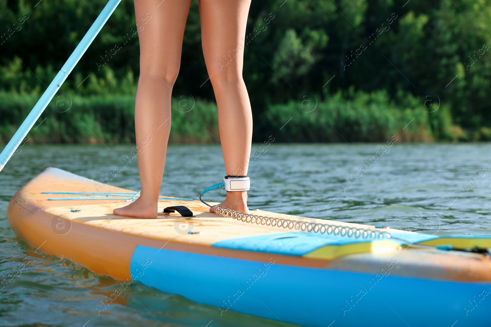 Photo of Woman paddle boarding on SUP board in river, closeup