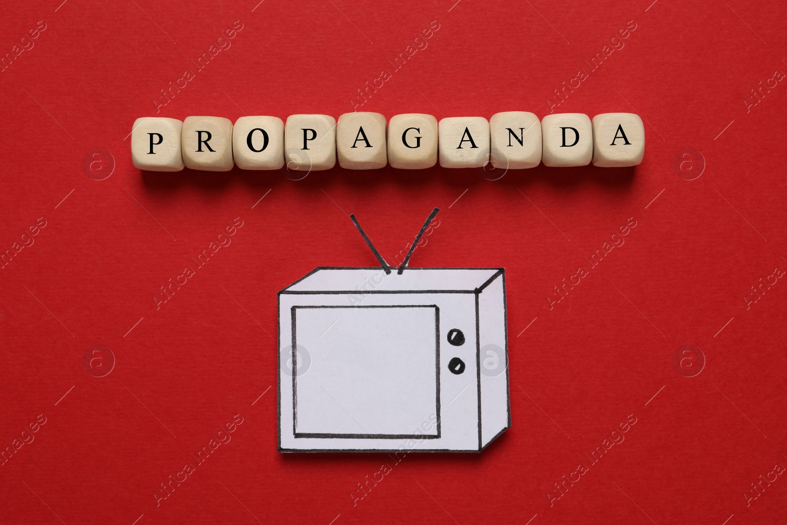 Photo of Word Propaganda made of wooden cubes and paper TV on red background, flat lay. Information warfare concept