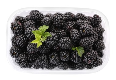 Photo of Tasty ripe blackberries in plastic container isolated on white, top view