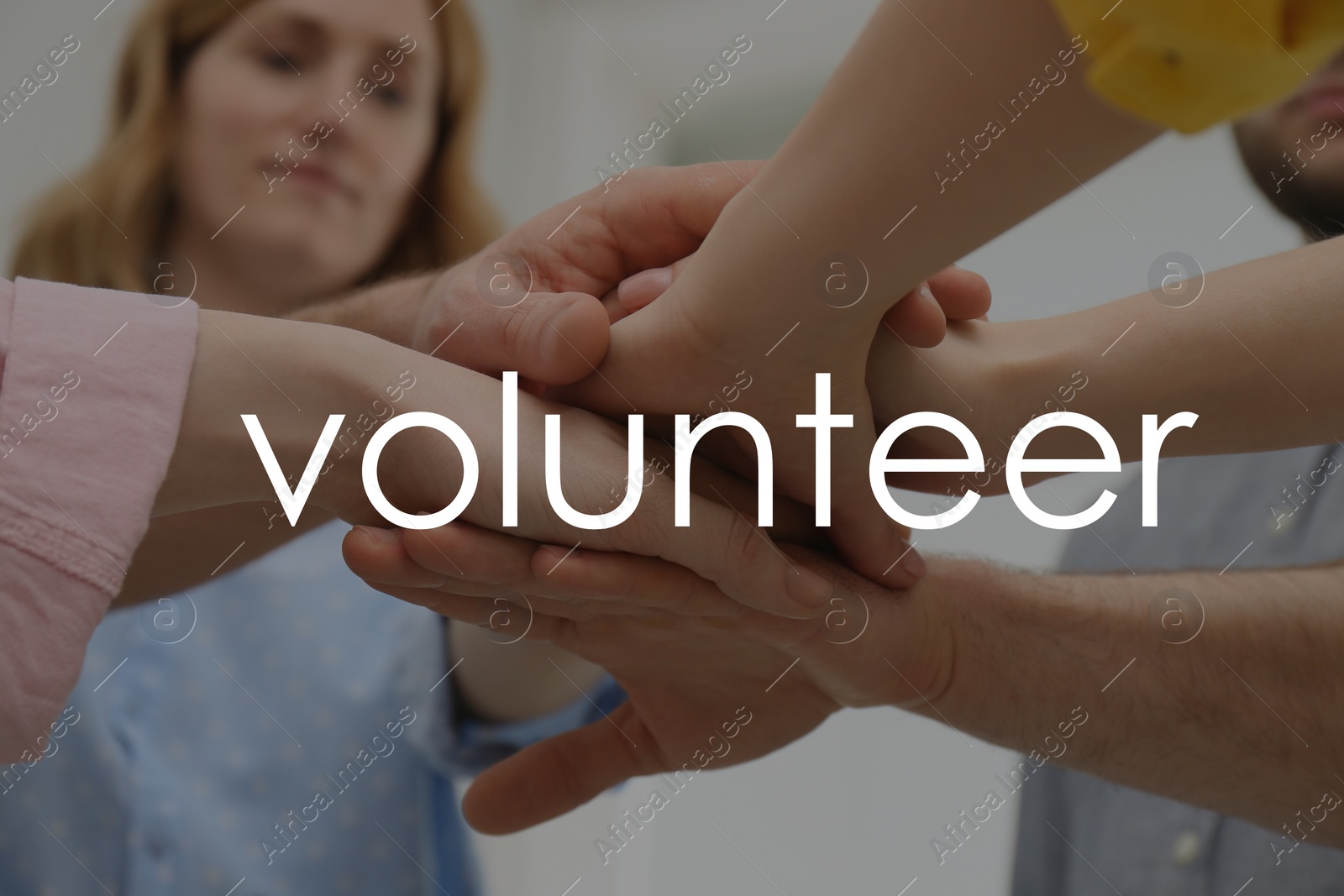 Image of Group of volunteers putting hands together indoors, closeup