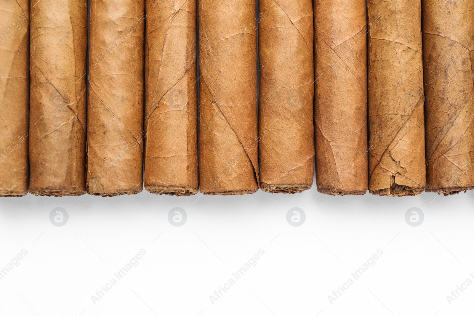 Photo of Many expensive cigars on white background, top view