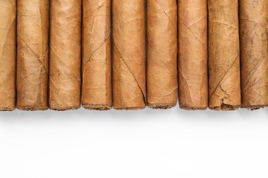 Photo of Many expensive cigars on white background, top view