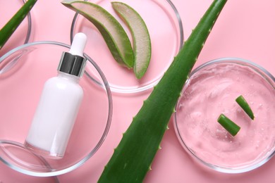 Photo of Flat lay composition with aloe vera leaves and cosmetic products on pink background