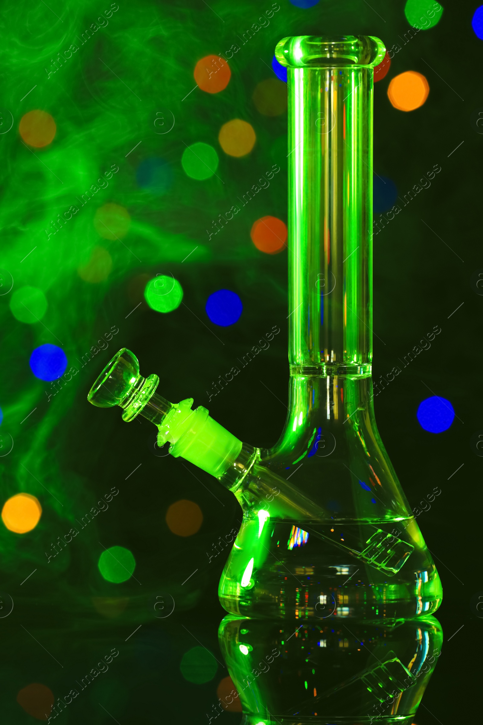 Photo of Glass bong with smoke against blurred lights, toned in green. Smoking device
