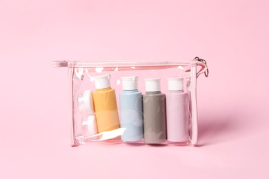 Cosmetic travel kit in plastic bag on pink background