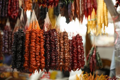 Photo of Bunches of different delicious churchkhelas at market