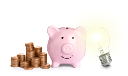 Image of Light bulb, piggy bank and stacked coins on white background. Energy efficiency, loan, property or business idea concepts