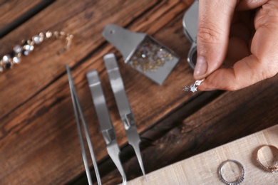 Male jeweler evaluating diamond ring in workshop, closeup view