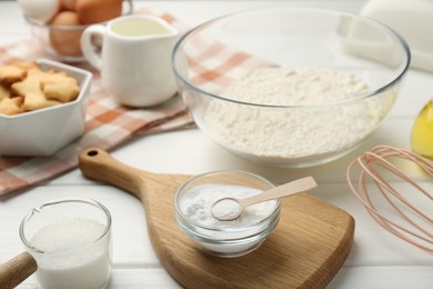 Photo of Baking powder and sugar on white wooden table, closeup