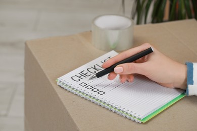 Photo of Woman filling Checklist on box, closeup view