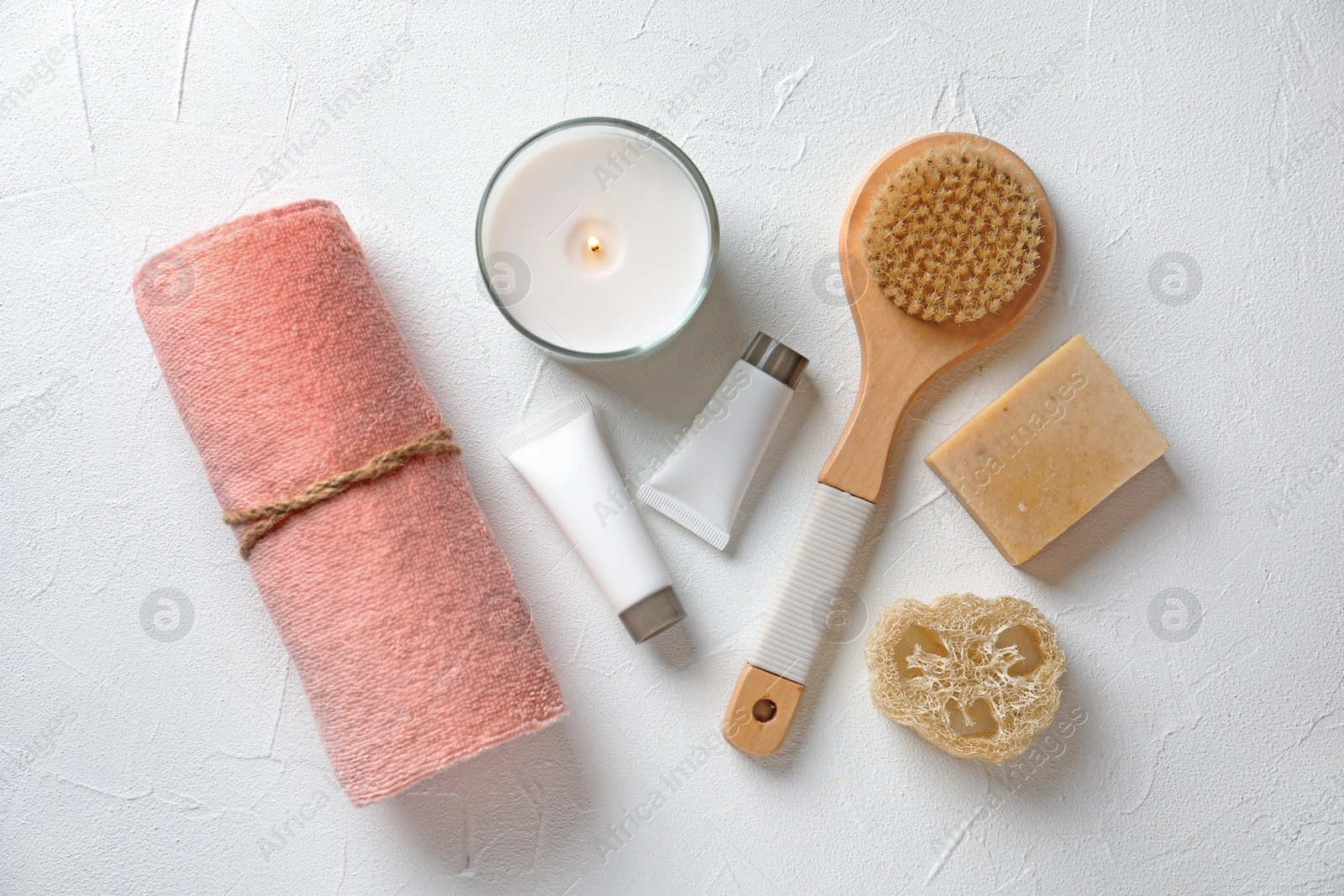 Photo of Flat lay composition with spa cosmetics and towel on white background