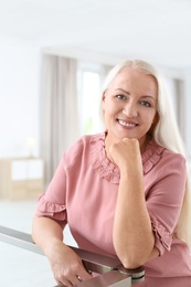 Portrait of beautiful older woman against blurred background