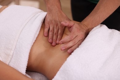 Photo of Woman receiving professional belly massage indoors, closeup