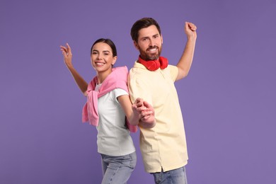 Photo of Happy couple dancing together on violet background