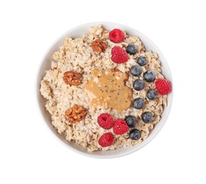 Photo of Tasty boiled oatmeal with berries, walnuts, chia seeds and peanut butter in bowl isolated on white, top view