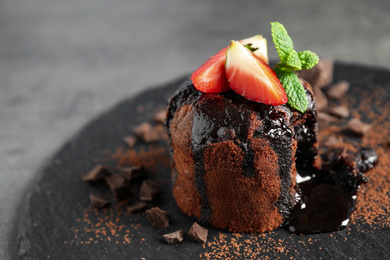 Photo of Delicious warm chocolate lava cake on slate board, closeup