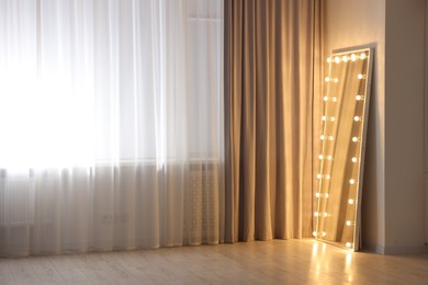 Photo of Modern mirror with light bulbs in makeup room