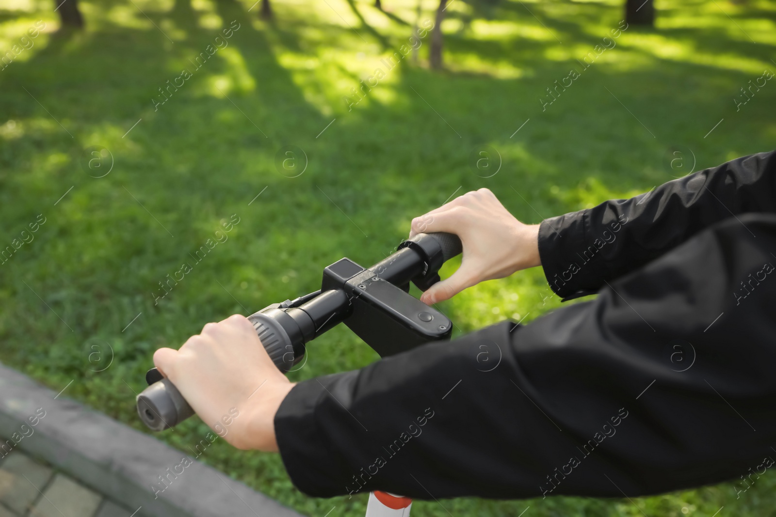 Photo of Man riding modern electric scooter in park, closeup