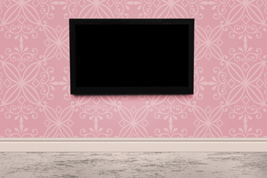Modern TV on pink wall in room. Space for design