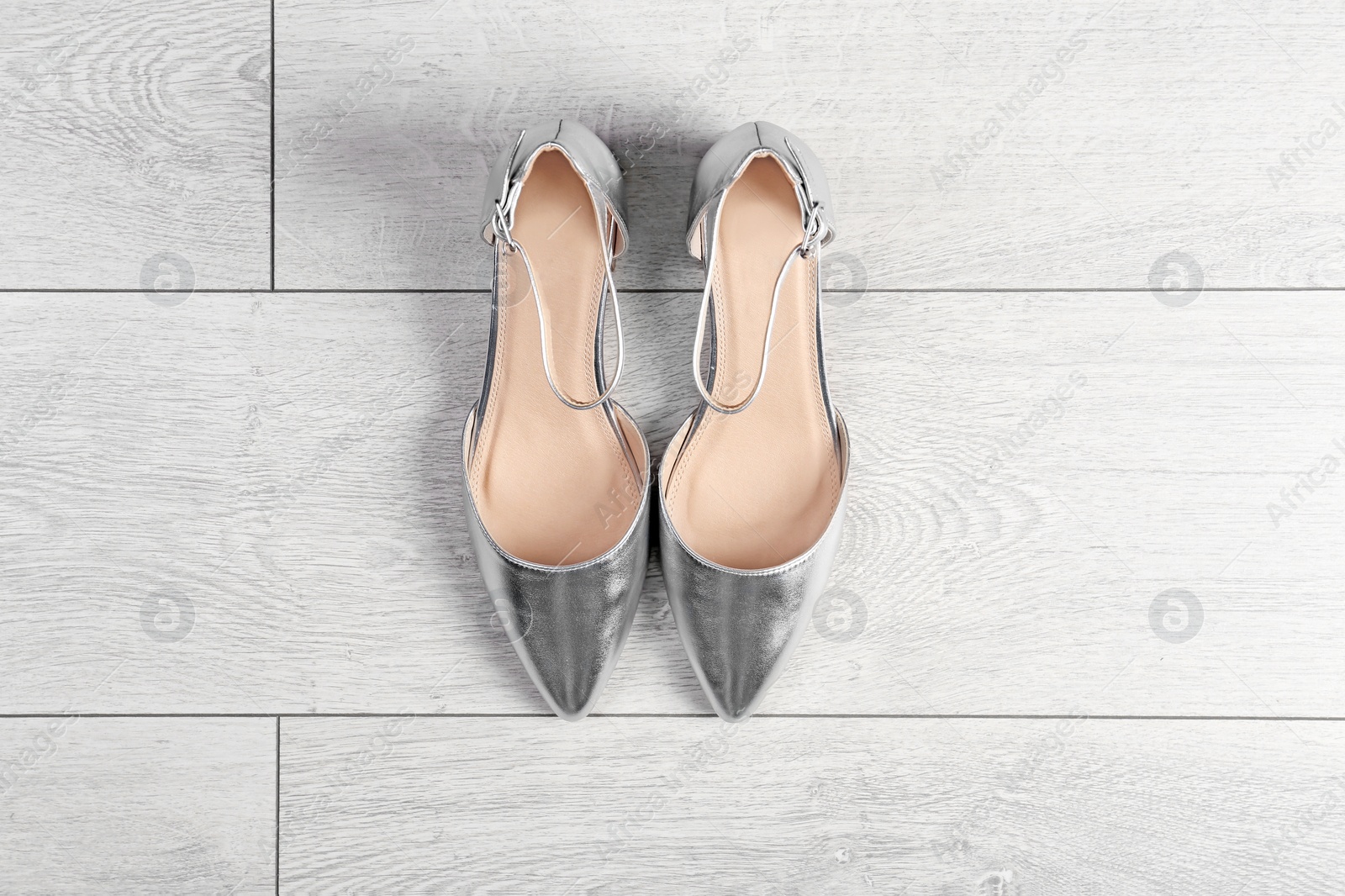 Photo of Pair of female shoes on wooden background, top view