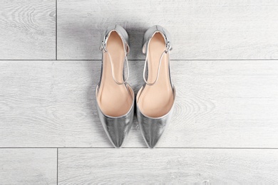 Photo of Pair of female shoes on wooden background, top view