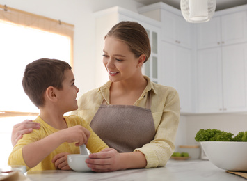 Family with mortar and pestle in kitchen. Cooking together