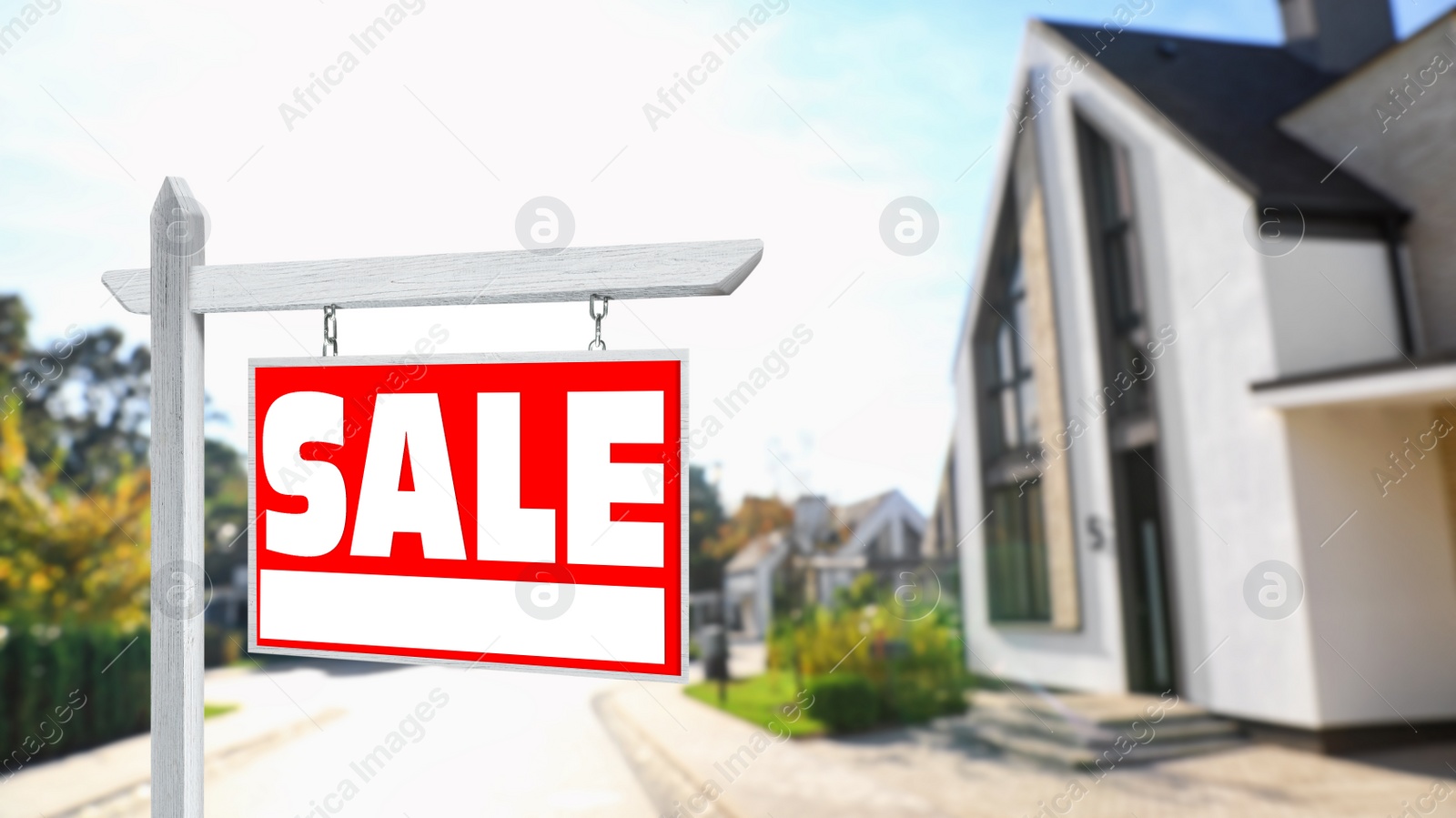 Image of Red real estate sign with inscription SALE near house outdoors on sunny day, space for text 