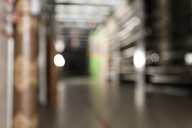 Blurred view of storage stands with different building materials in wholesale warehouse