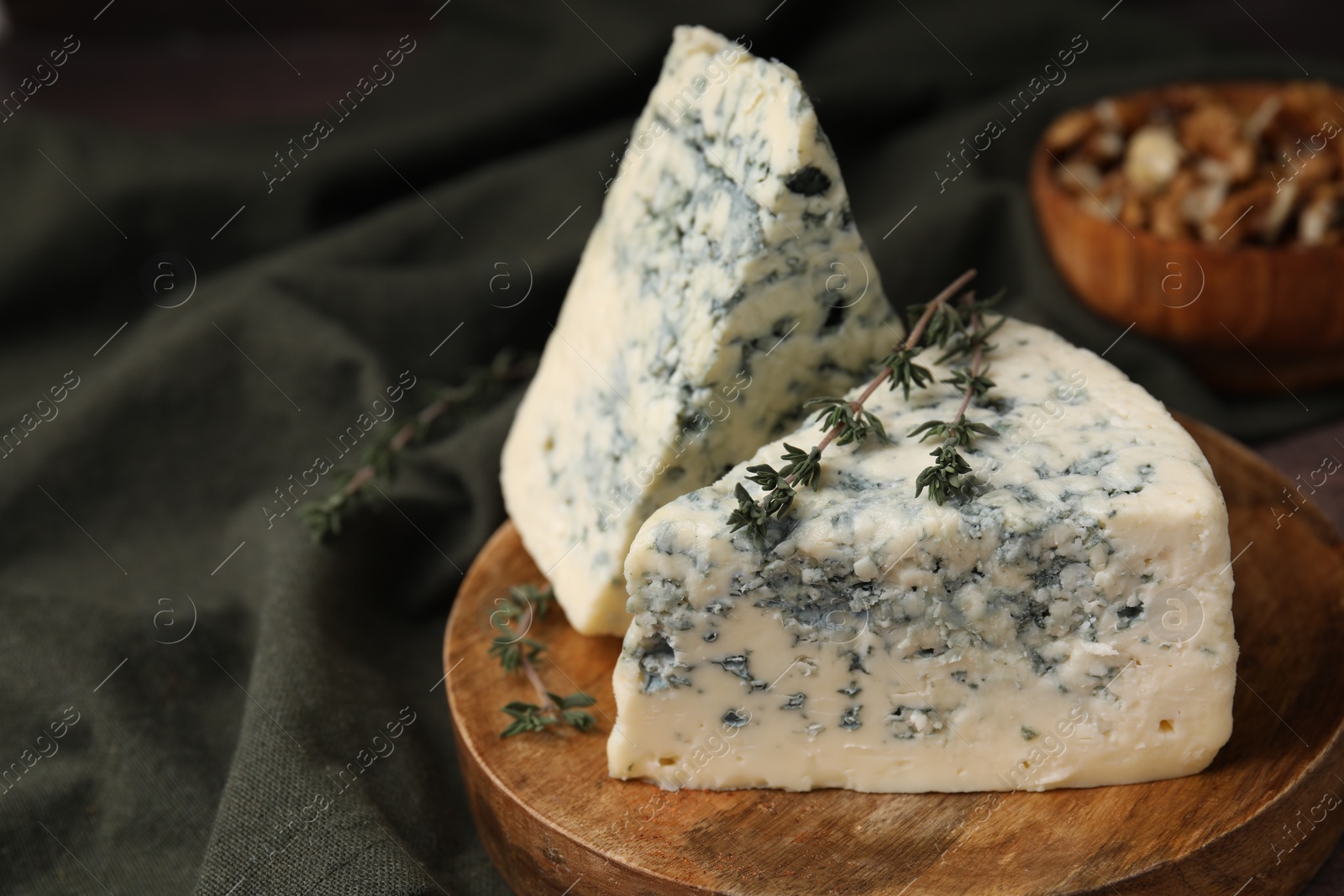 Photo of Tasty blue cheese with thyme on table. Space for text