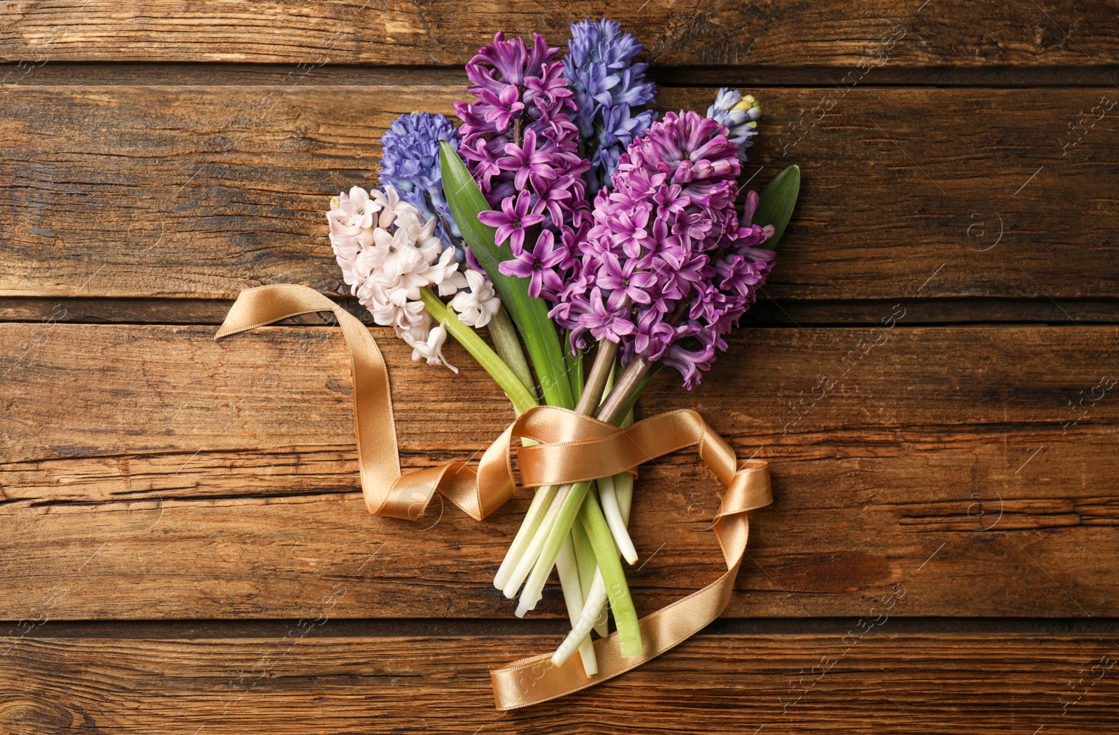 Photo of Beautiful spring hyacinth flowers on wooden table, top view