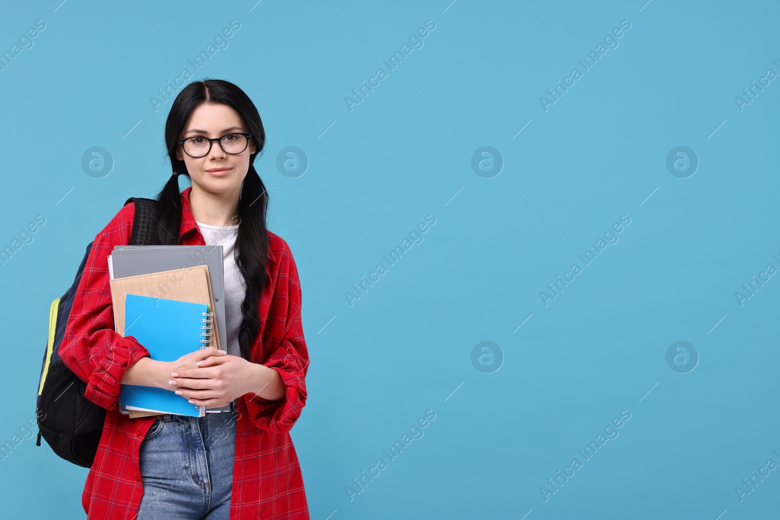 Photo of Student with notebooks, folder and backpack on light blue background. Space for text