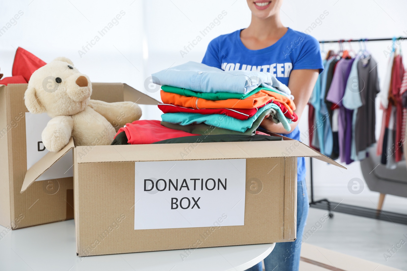 Photo of Female volunteer collecting donations at table indoors