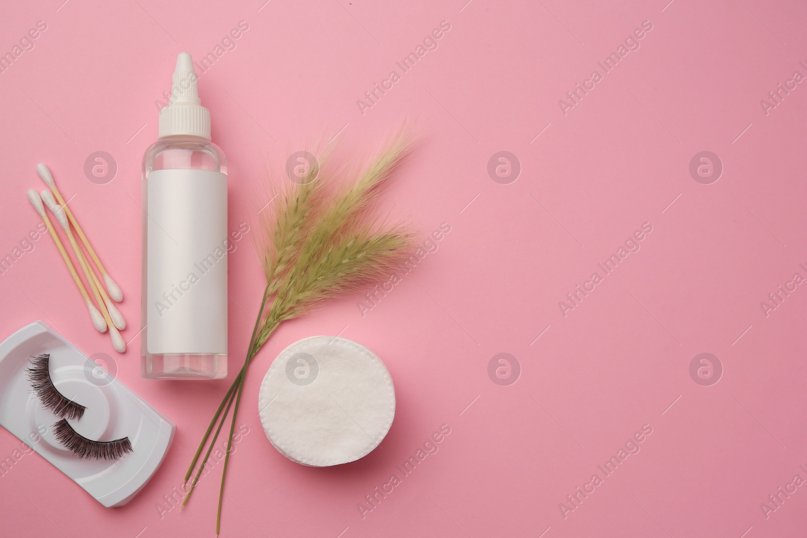 Photo of Flat lay composition with makeup remover and false eyelashes on pink background. Space for text