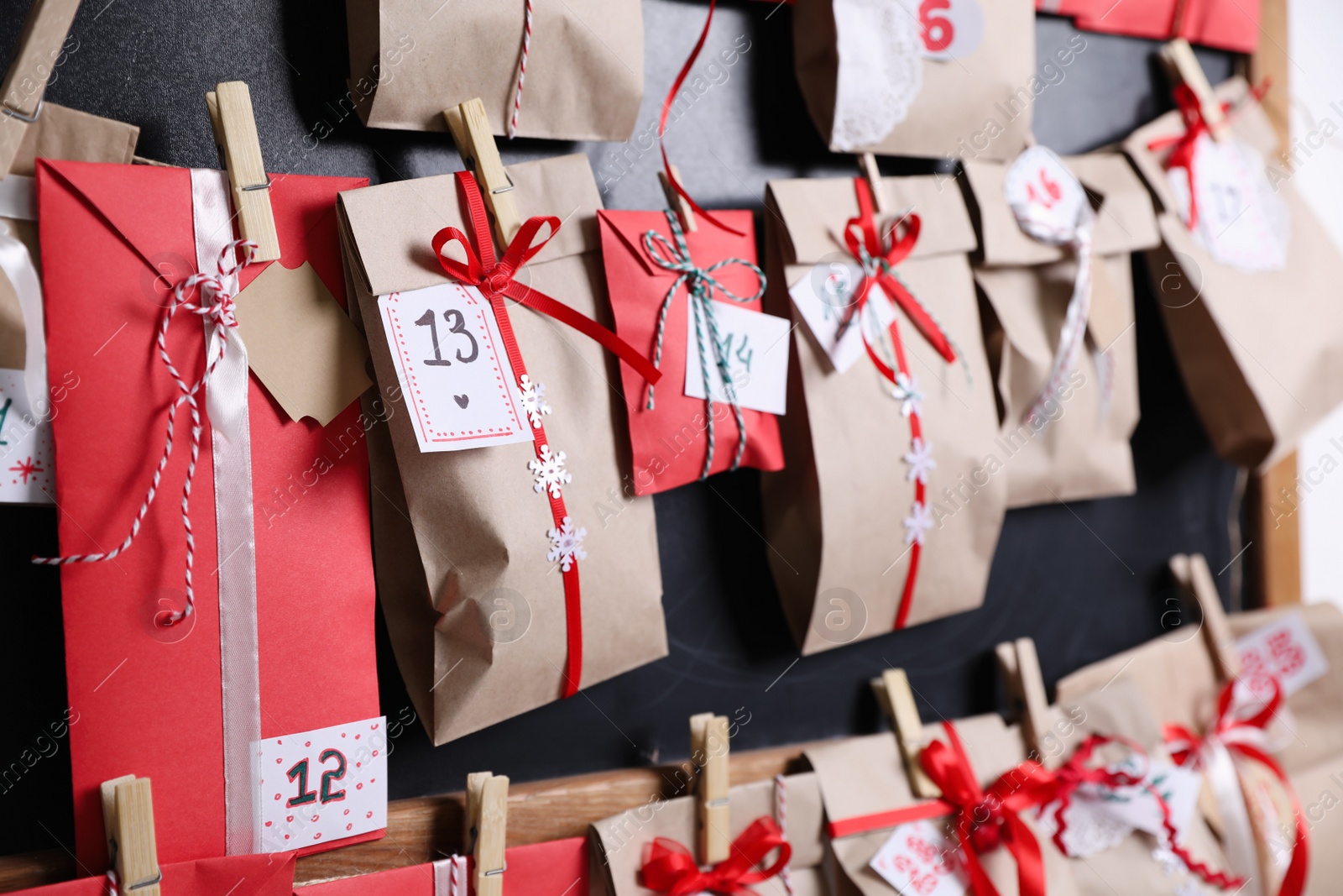 Photo of Christmas advent calendar hanging on blackboard, closeup