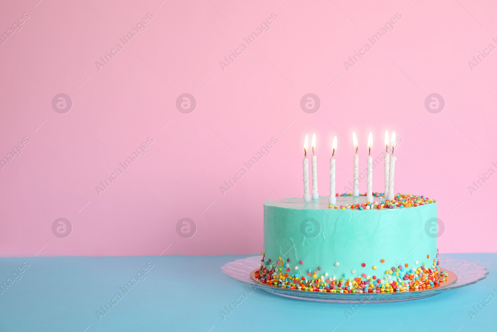 Photo of Fresh delicious birthday cake with candles on table against color background. Space for text