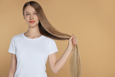 Photo of Teenage girl with strong healthy hair on beige background, space for text