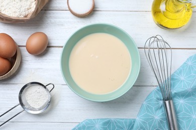 Batter for thin pancakes and products on white wooden table, flat lay