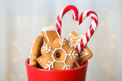 Cup with tasty homemade Christmas cookies on blurred background