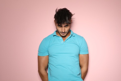 Photo of Young man with trendy hairstyle posing on color background